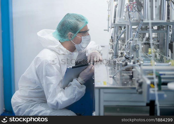 Workers producing surgical mask in modern factory, Covid-19 protection and medical concept.