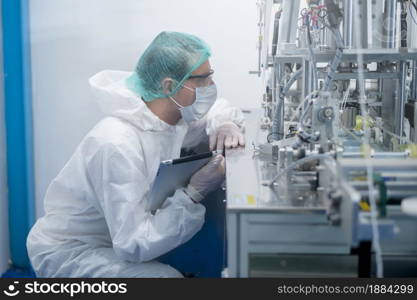 Workers producing surgical mask in modern factory, Covid-19 protection and medical concept.