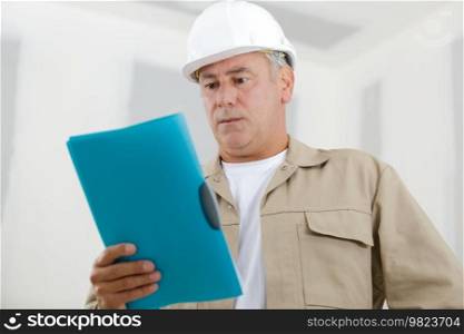 workers reading clipboard on site