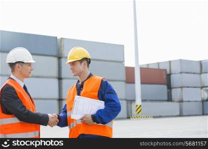 Workers shaking hands in shipping yard