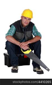 Workers sitting on toolbox with saw in hand