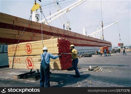 Workers unloading a shipment of treated lumber