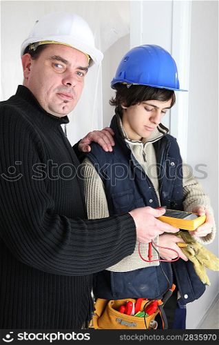 Workers using a multimeter