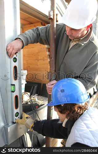 Workers using a spirit level