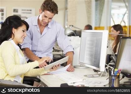 Workers Using Digital Tablet In Busy Creative Office
