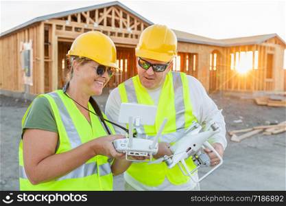 Workers with Drone Quadcopter Inspecting Photographs on Controller At Contruction Site.