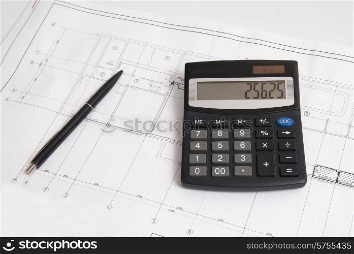 Working drawing with calculator and pen. Engineering equipment.