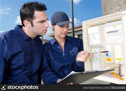 working electricians measure the voltage with a multimeter
