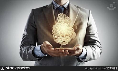 Working gear mechanism. Close up of businessman in suit holding metal gears in hands