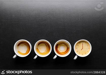 working hours. empty and full cups of fresh espresso with clock sign, view from above