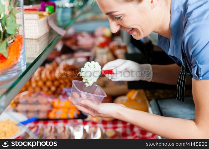 Working in a butcher&acute;s shop - a shop assistant with curd cheese