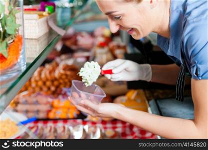 Working in a butcher&acute;s shop - a shop assistant with curd cheese