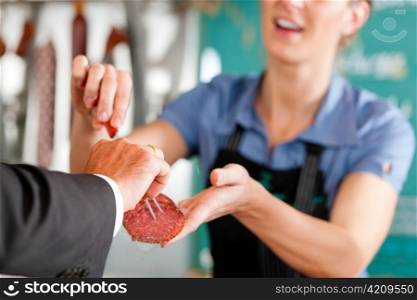 Working in a butcher&acute;s shop - shop assistant and client