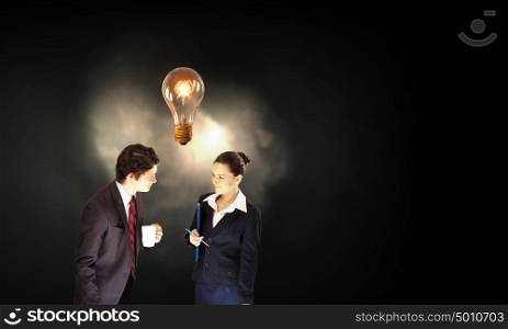 Working in collaboration. Partnership concept with businessman and businesswoman and glowing light bulb