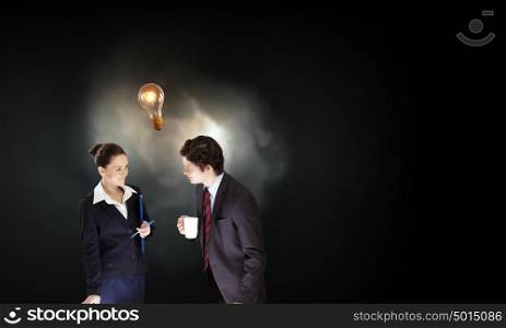 Working in collaboration. Partnership concept with businessman and businesswoman and glowing light bulb