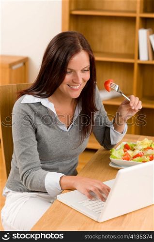 Working lunch at home attractive woman with laptop eat salad