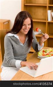 Working lunch at home attractive woman with laptop eat salad