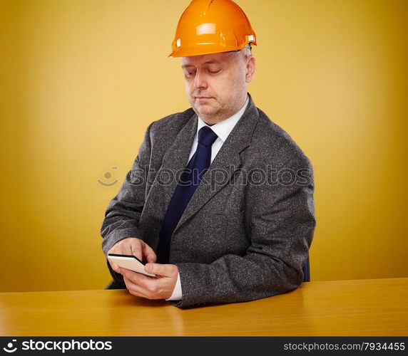 Working male engineer in office, he wearing a white shirt and tie and coat, head he wears a orange hard hat