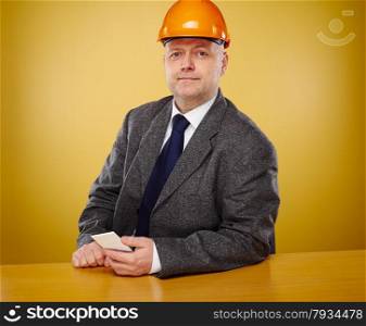 Working male engineer in office, he wearing a white shirt and tie and coat, head he wears a orange hard hat