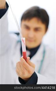 Working male researcher. Focus on pipette pouring samples in test tube