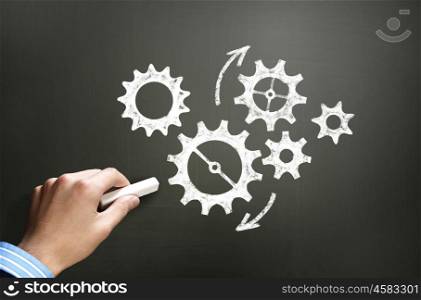 Working mechanism. Businessman hand drawing with chalk gears mechanism as teamwork concept