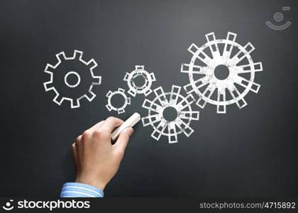 Working mechanism. Businessman hand drawing with chalk gears mechanism as teamwork concept