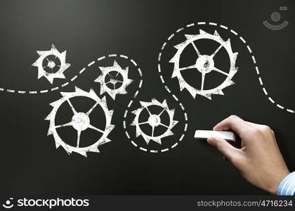 Working mechanism. Businessman hand drawing with chalk gears mechanism as teamwork concept