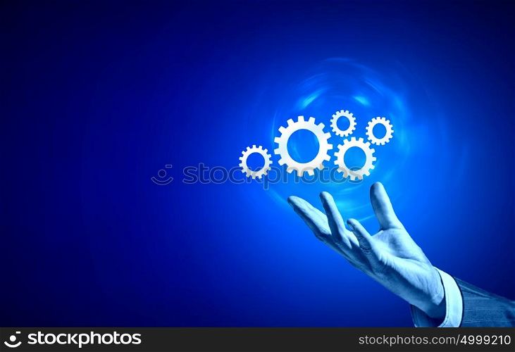 Working mechanism. Businessperson hand holding gears and cogwheels in palm