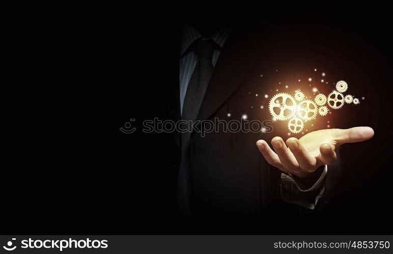 Working mechanism. Businessperson holding gears and cogwheels in palm