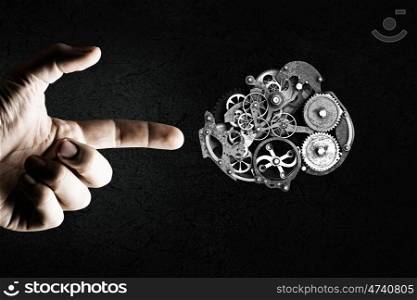 Working mechanism. Close up of hand and gears mechanism on black background