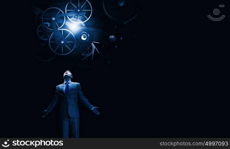 Working mechanism for business. Businessman with hands spread apart looking above at gears mechanism