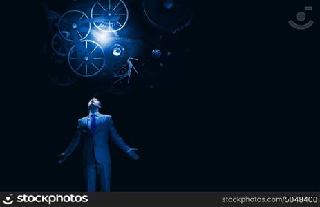 Working mechanism for business. Businessman with hands spread apart looking above at gears mechanism