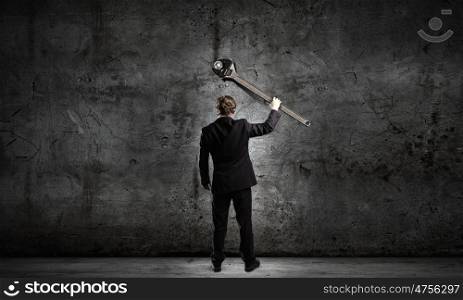Working mechanism. Rear view of young businessman with wrench