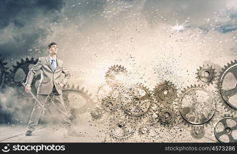 Working mechanism. Young businessman fixing gears mechanism with wrench