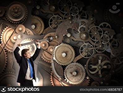 Working mechanism. Young businessman fixing gears mechanism with wrench