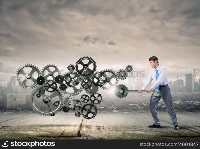 Working mechanism. Young determined businessman with wrench fixing mechanism