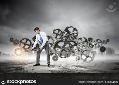 Working mechanism. Young determined businessman with wrench fixing mechanism