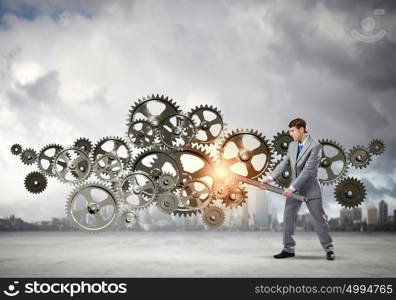 Working mechanism. Young determined businessman with wrench fixing mechanism