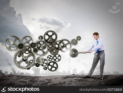 Working mechanism. Young determined businessman with wrench fixing mechanism