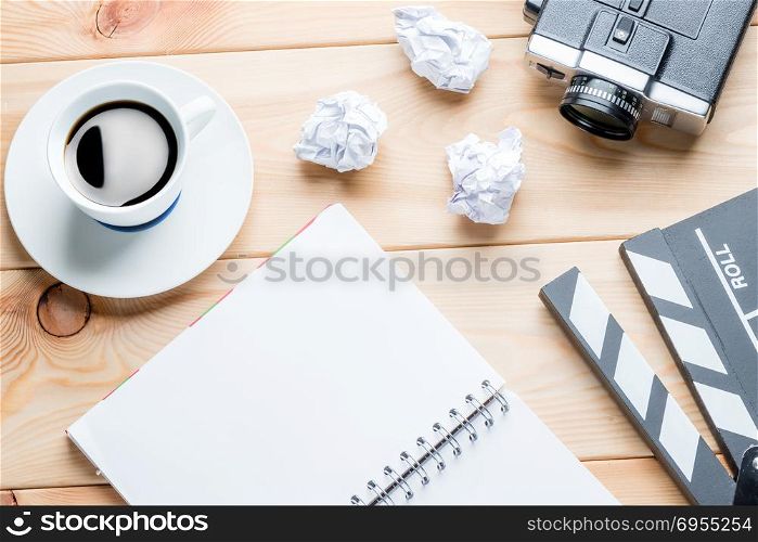 working moments of the writer - notepad, crumpled paper and video camera on wooden boards objects of the film industry