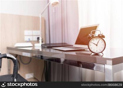 Working space at home or business desk table with alarm clock,  morning at home office hours work time concept.
