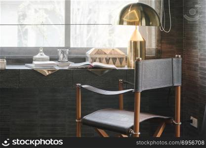working table with wooden chair, books and lamp in modern working room