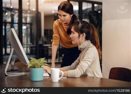 Working Together. Stressed Two Business Woman Workigng on Computer in Modern Office. Female Boss and Employee