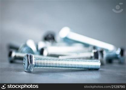 Working tool. Bolts on a gray background. High quality photo. Working tool. Bolts on a gray background.