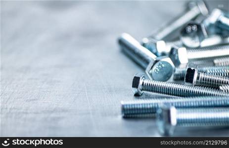 Working tool. Bolts on a gray background. High quality photo. Working tool. Bolts on a gray background.