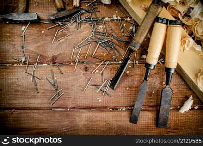 Working tool. Chisel, hammer and nails. On a wooden background. High quality photo. Working tool. Chisel, hammer and nails.
