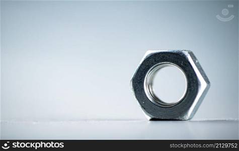 Working tool. Metal nuts on the table. On a gray background. High quality photo. Working tool. Metal nuts on the table.