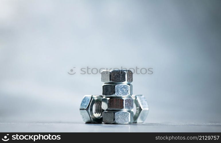 Working tool. Metal nuts on the table. On a gray background. High quality photo. Working tool. Metal nuts on the table.