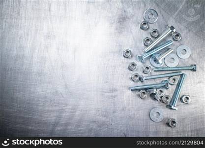 Working tool. Nuts and bolts on the table. On a gray background. High quality photo. Working tool. Nuts and bolts on the table.