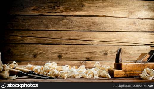 Working tool on wood on with shavings. On a wooden background. High quality photo. Working tool on wood on with shavings.